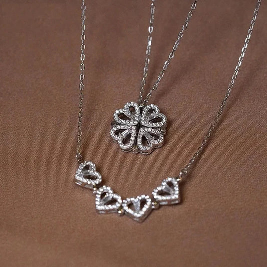 A gold necklace with a silver pendant in the shape of four hearts